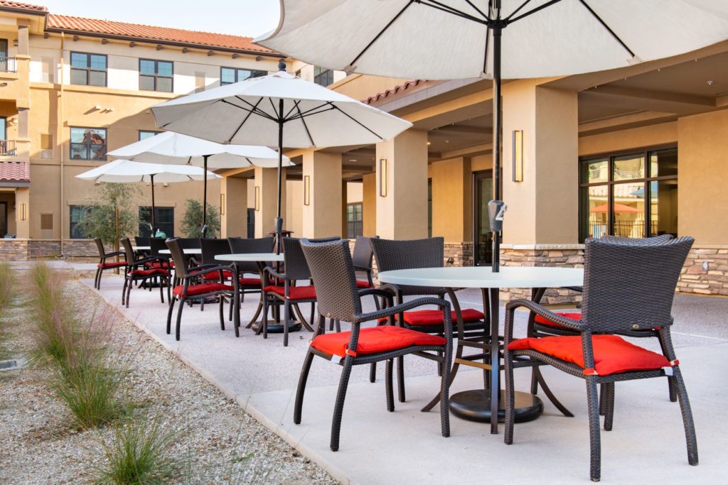 exterior patio area with chairs, tables, and umbrellas