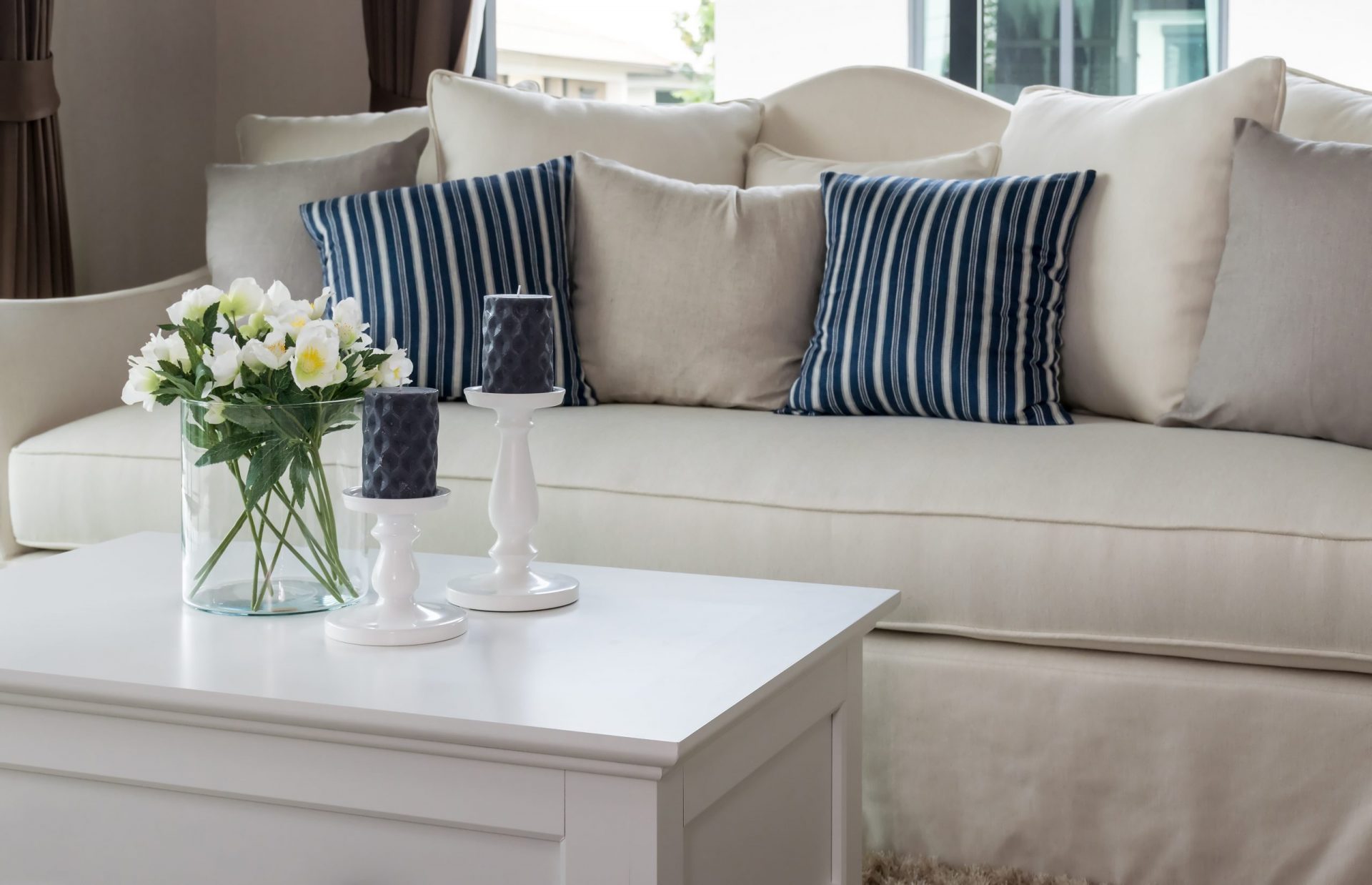 modern living room with glass vase and row of pillows