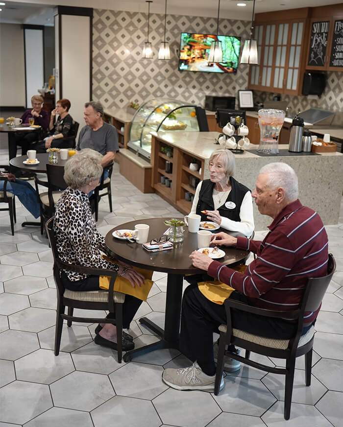 Residents enjoy a meal in the dining area of a community center.
