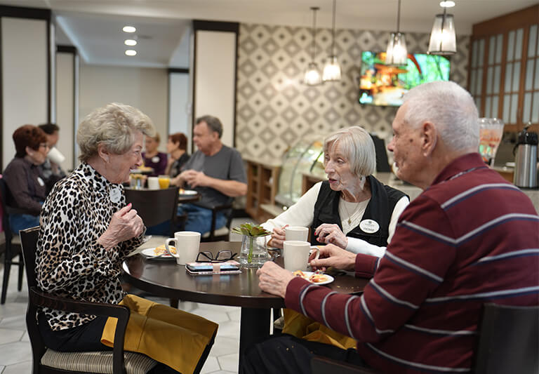 Residents enjoying a meal in a dining area of a senior living community.