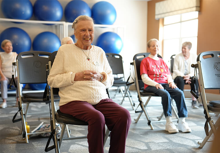 Elderly women sitting in exercise at senior community with blue exercise balls.