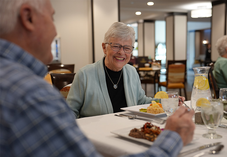 Senior woman laughing at dinner