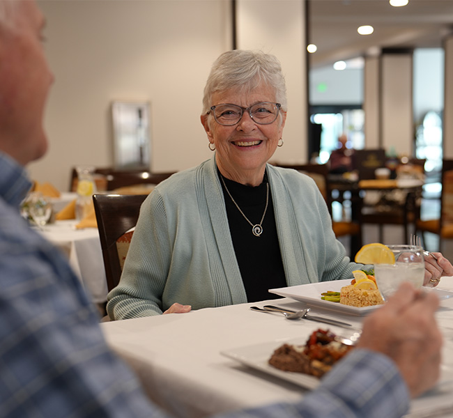 Senior woman enjoying dinner with man